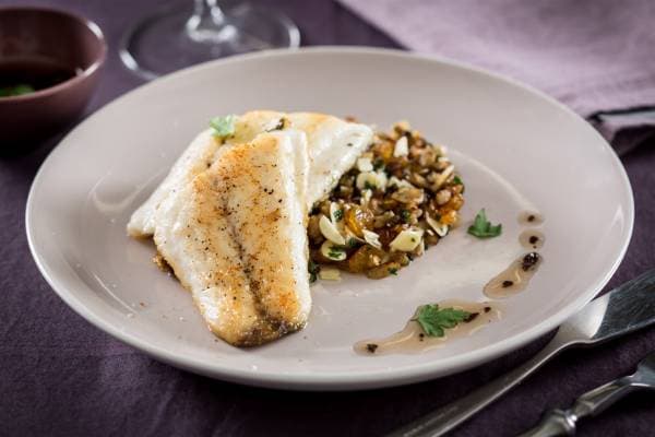 Filet de bar piqué à l'olive verte, mitonnée d'aubergines et amandes torréfiées