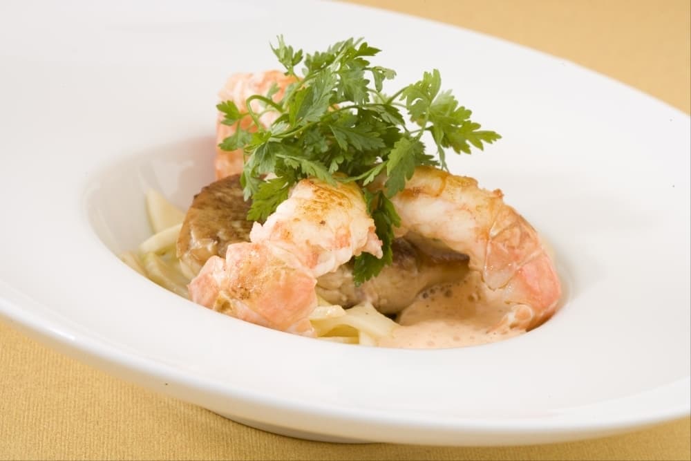 Queues de langoustines en brochette de citronnelle, foie gras et céleri poêlés, jus de crustacés