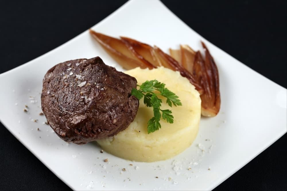 Pavé de boeuf piqué au cognac, pommes de terre écrasées et échalotes confites
