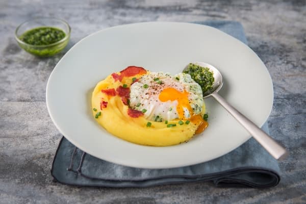 Œuf poché, crème de carottes jaunes, tuile de bacon et pesto de fanes