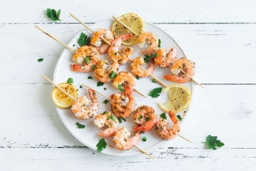 Brochette de gambas marinées au citron vert, salade de fenouil croquant au curry sur un écrasé de pomme de terre