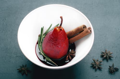 Poire pochée au vin rouge épicé, chantilly citron vert, chocolat chaud et crumble de fruits secs