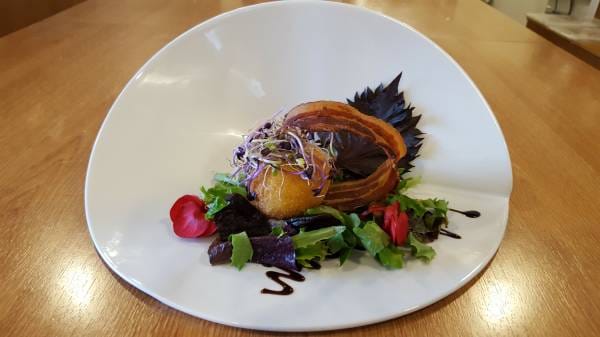 Oeuf mollet pané sur mesclun et jeunes pousses, tuile de lard fumé