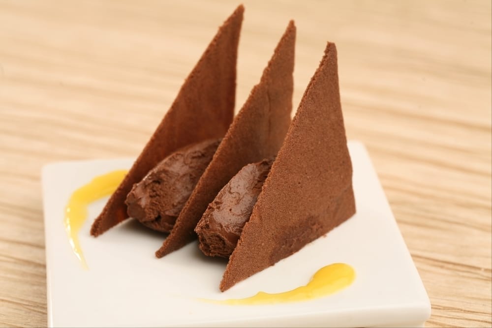 Tuiles au cacao, mousse choco-passion et coulis de jus de mangue.