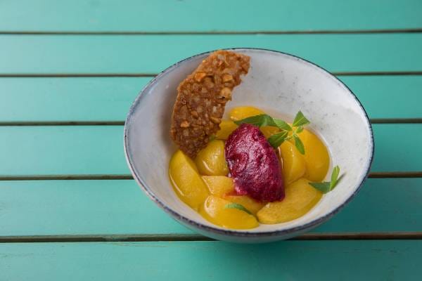 Pêche pochée à la verveine, sorbet minute au cassis et tuile noisette