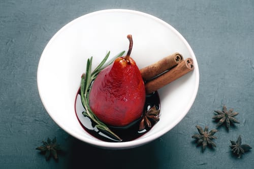 Poire pochée au vin rouge épicé, chantilly citron vert, chocolat chaud et crumble de fruits secs