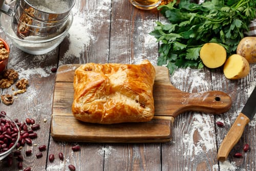 Feuilleté de saumon au beurre d’herbes, salade de mâche, champignons de Paris, julienne de pomme verte et éclats de noix 