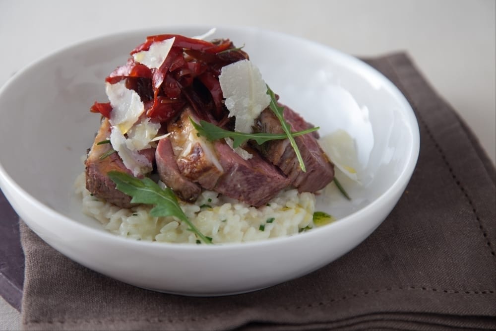 Filet d'agneau parsemé d'ail et de romarin, risotto aux herbes, chutney de poivrons et germes de petits pois